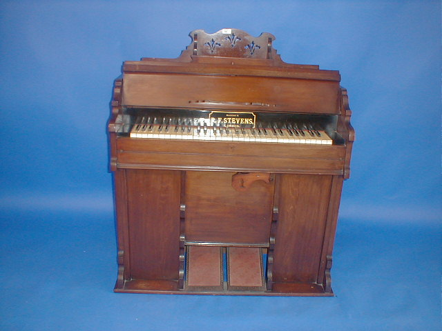 A Victorian walnut cased harmonium manufactured by R F Stevens