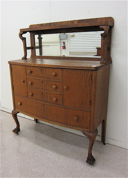 AN OAK BOW FRONT SIDEBOARD American c 1900 having a