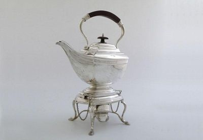 A silver kettle on stand of shaped rectangular form central