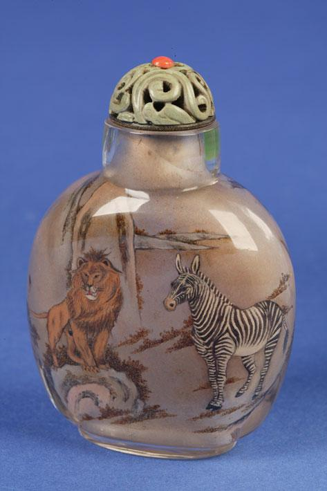 AN INSIDE PAINTED GLASS BOTTLE decorated with a lion zebra