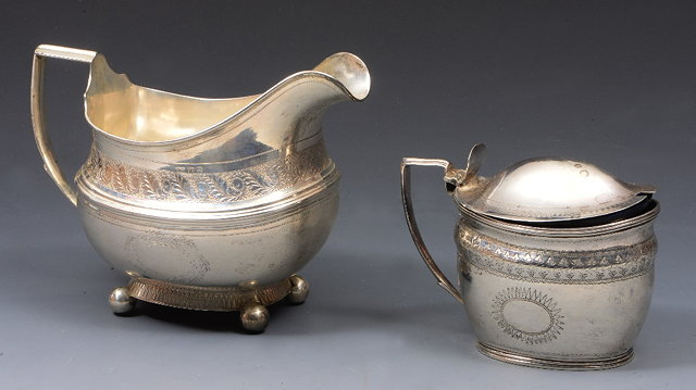 A GEORGIAN SILVER OVAL SHAPED CREAM JUG with engraved foliate
