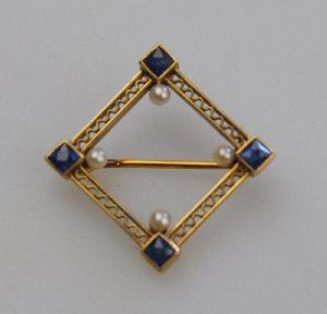 Open style geometric design brooch having square cut sapphire and