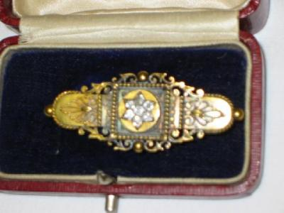 A VICTORIAN GOLD BAR BROOCH with seven diamonds centrally set