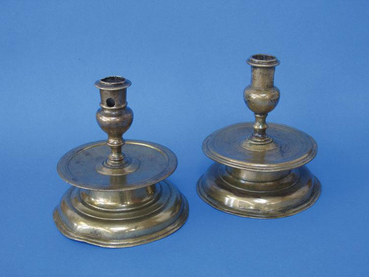 TWO SIMILAR 17TH CENTURY CAPSTAN TYPE CANDLESTICKS with socket candle