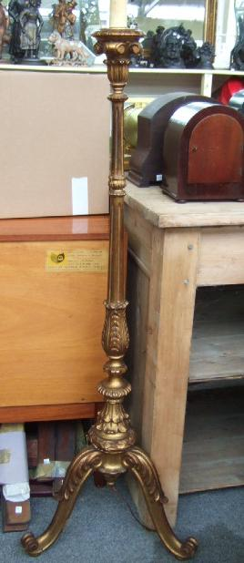 A giltwood standard lamp with leaf clasped baluster supports and