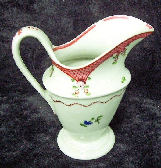 An oval Newhall cream jug on a circular pedestal base