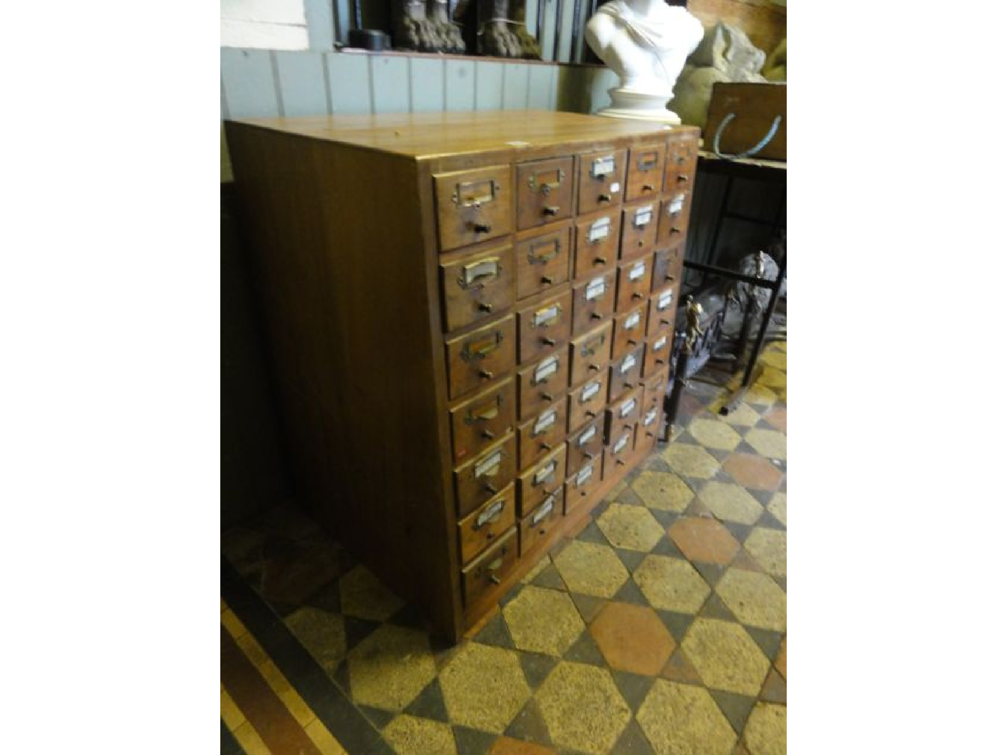 A vintage floor standing flight of thirty small index filing