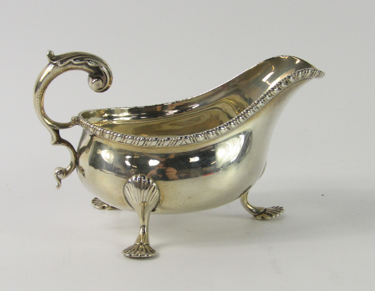 A Victorian silver sauce boat with a gadrooned rim raised