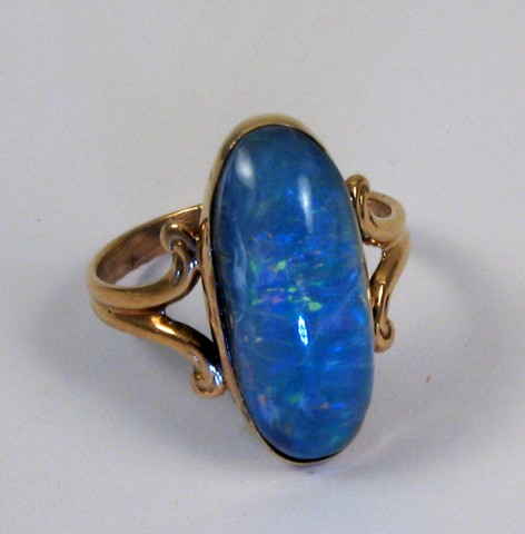 OPAL AND TEN KARAT GOLD RING set with an oval