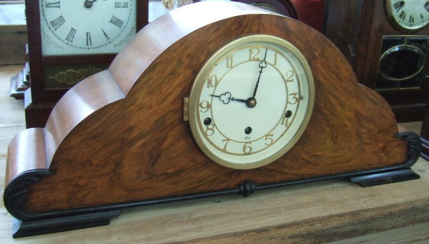 A walnut and ebonised cloud shape mantel clock early 20th