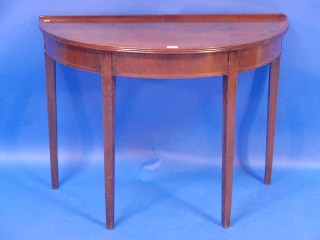A George III inlaid mahogany demi lune table with reeded