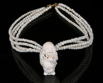 A Carved Netsuke Pendant on a Beaded Necklace Carved ivory