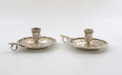 A pair of silver chamber sticks of shaped circular form