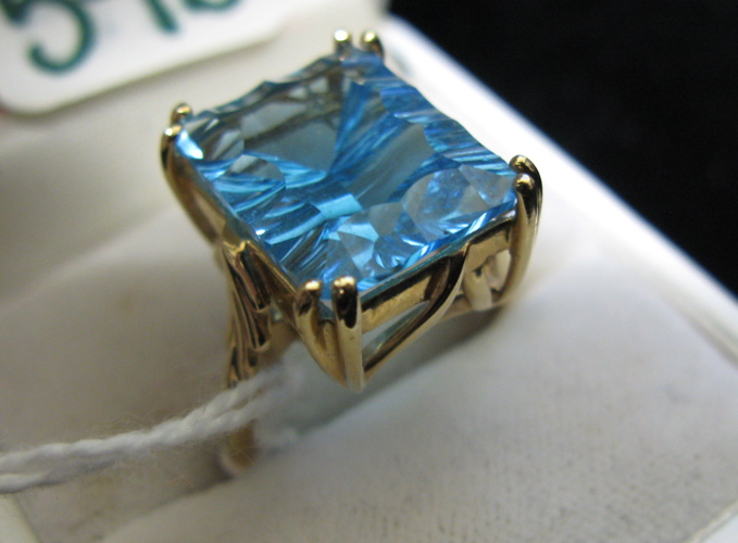 BLUE TOPAZ AND FOURTEEN KARAT GOLD RING set with a