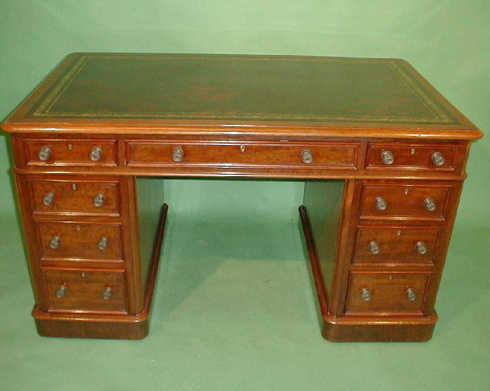 A Victorian mahogany kneehole desk with an arrangement of frieze