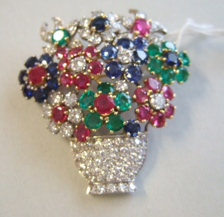 A gold diamond emerald sapphire and ruby set brooch designed