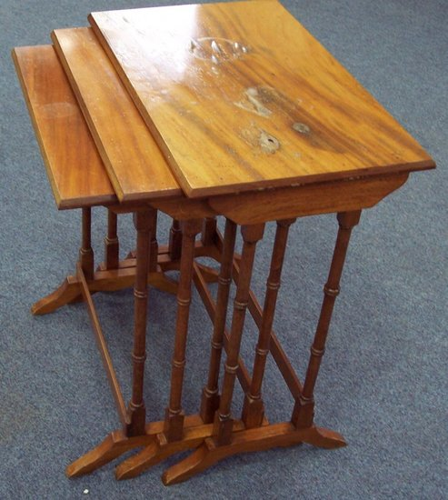 A nest of three satinwood tables on spindle turned supports