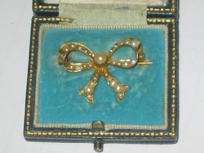 A VICTORIAN PEARL BROOCH modelled as a bow in yellow