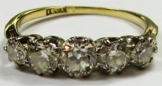 A gold and diamond set five stone ring mounted with