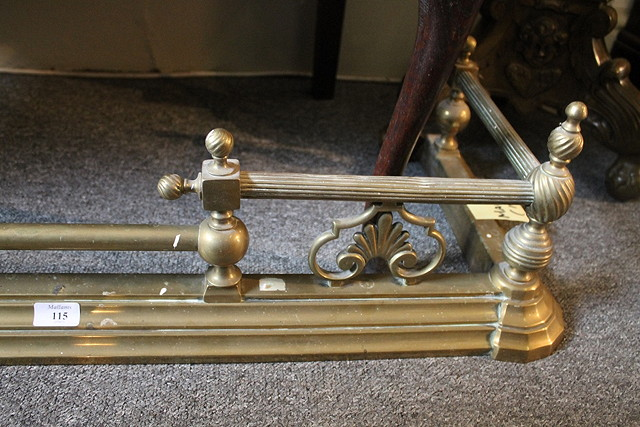 AN EDWARDIAN BRASS FIRE GUARD with turned rails 153cm across
