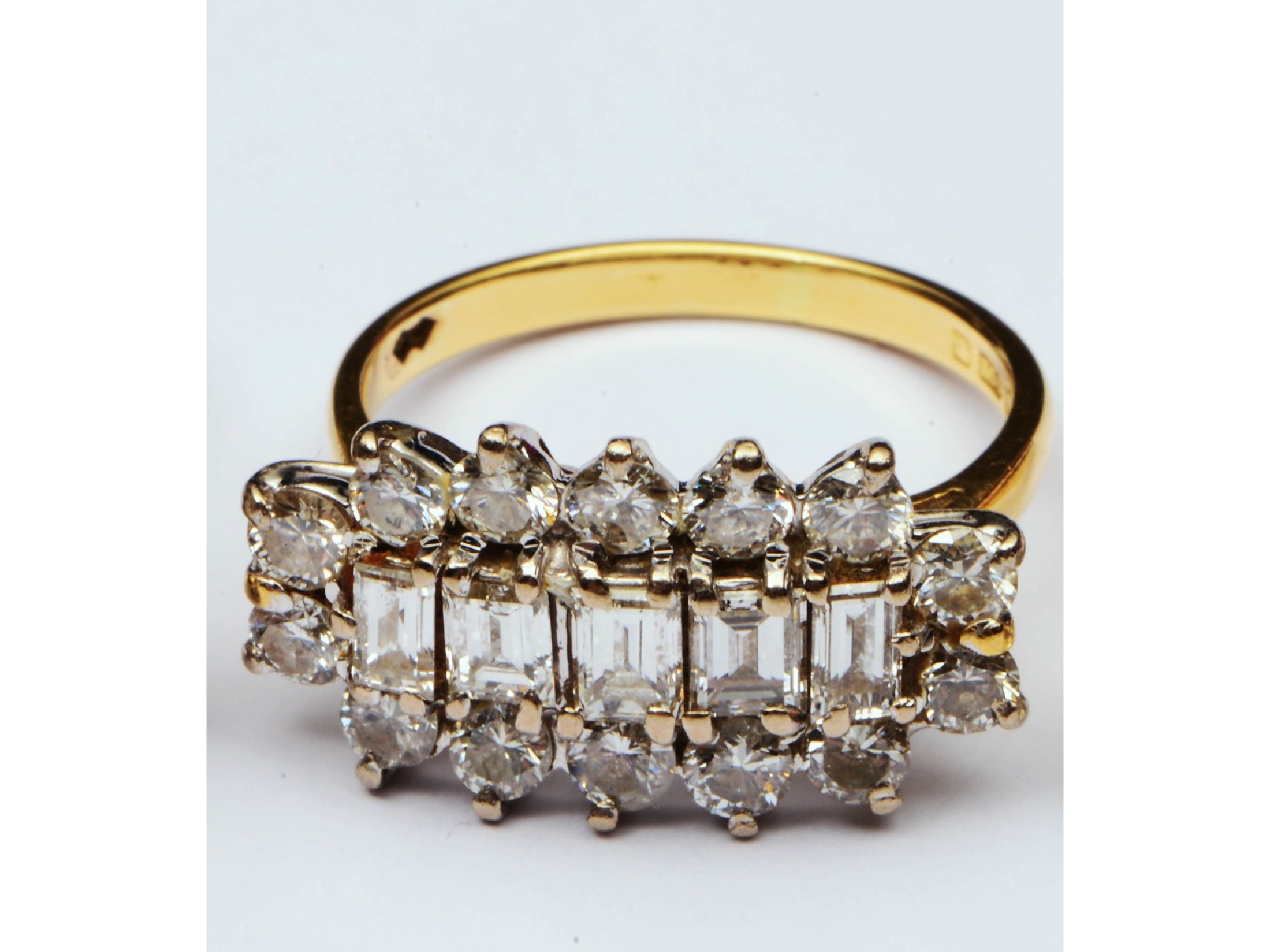 A diamond cluster ring centred with a row of five