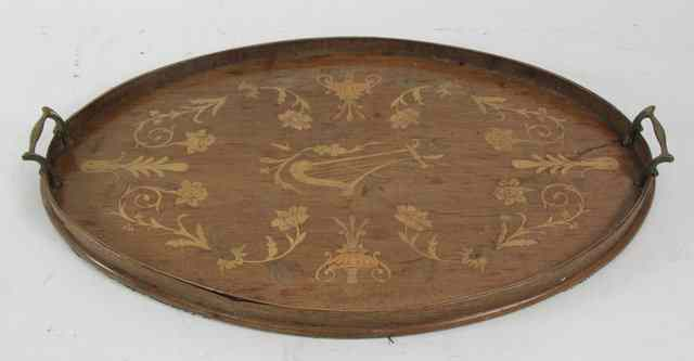 An Edwardian oval mahogany tray inlaid a central harp with