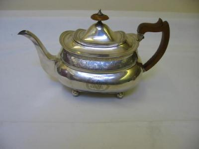 A GEORGE III TEAPOT of dished bombe oblong form chased