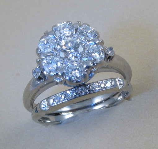 DIAMOND AND EIGHTEEN KARAT GOLD RING set with seven round