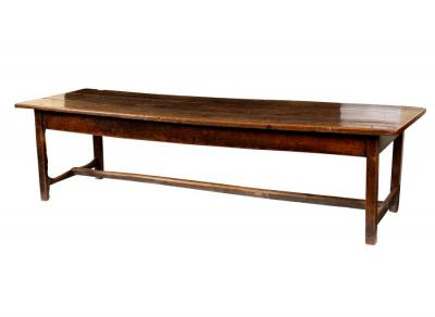 An oak refectory table raised on square legs united by