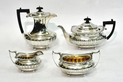 AN EDWARDIAN FOUR PIECE TEA SET of half fluted oblong