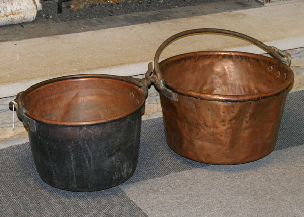 Two large copper kettles with swivel bail handles hand forged