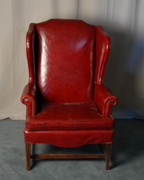 A Wingback Chair upholstered in faux red leather and with