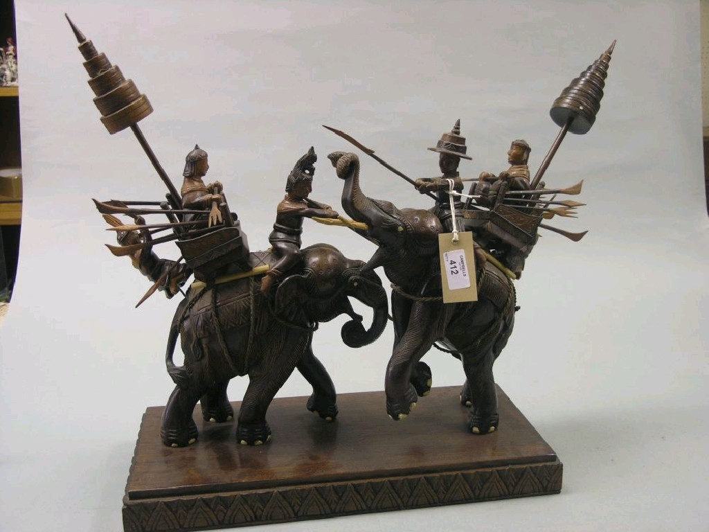 A Tibetan carved wood elephant group depicting a ceremonial occasion