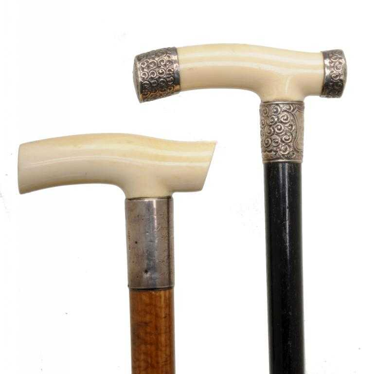 TWO VICTORIAN IVORY HANDLED WALKING CANES with handles of tau