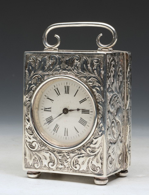 A FRENCH CARRIAGE CLOCK with embossed silver case and acanthus