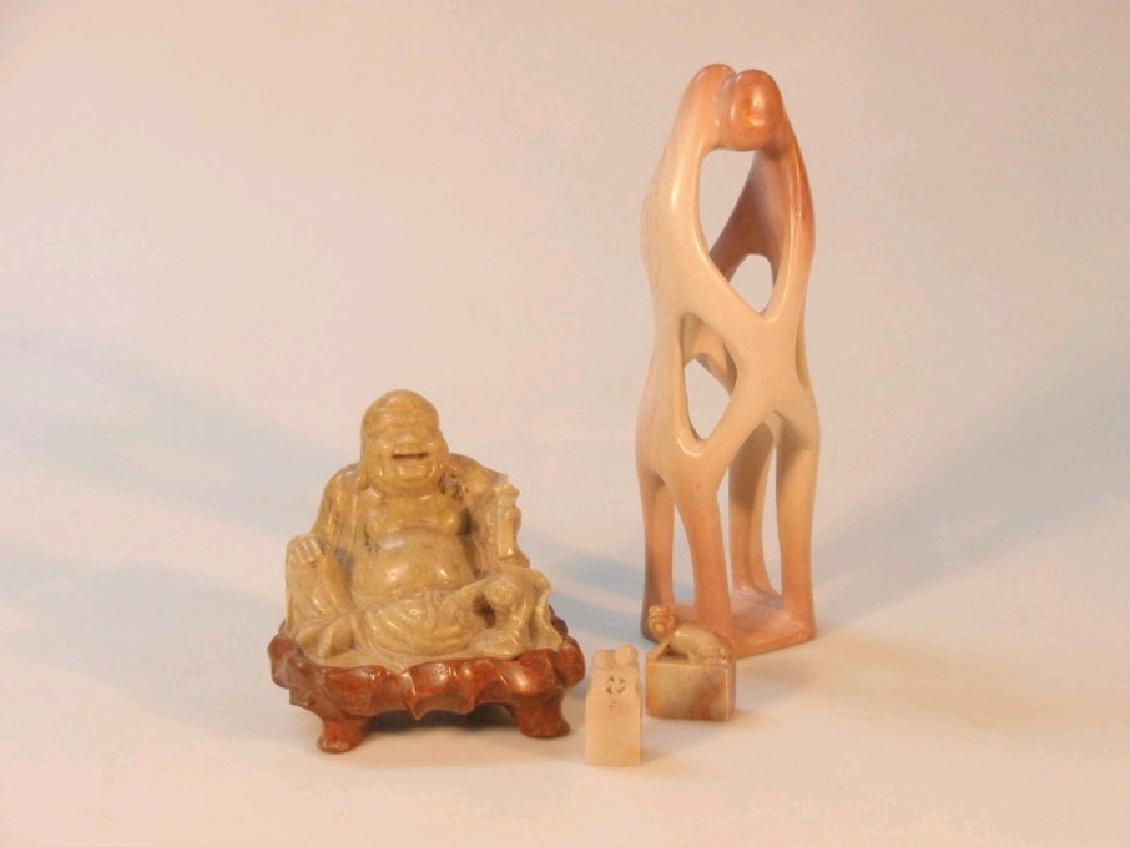 A carved soapstone figure of a seated Buddha pair of