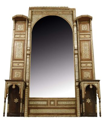 A large Moorish walnut wall mirror the arched bevelled plate
