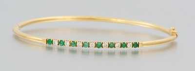 A Ladies Emerald and Diamond Bangle Bracelet 14k yellow gold