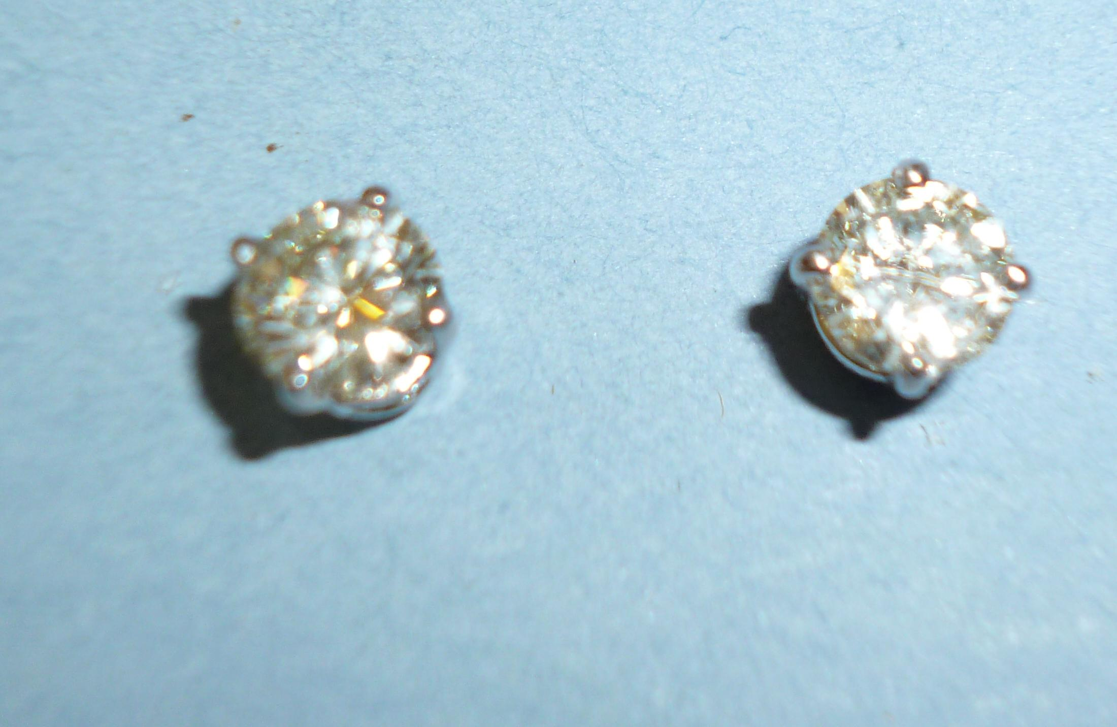A PAIR OF DIAMOND STUD EARRINGS the brilliant cut stones