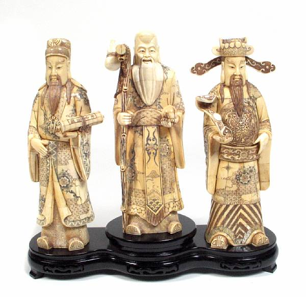 A set of three carved bone veneer and enameled figures