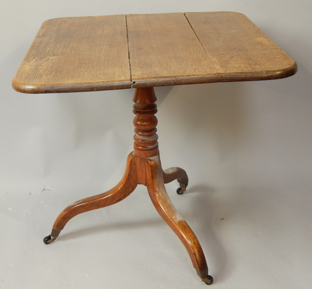An early 19thC oak and mahogany tilt top table with