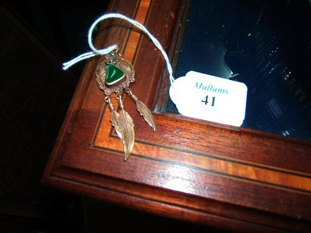 A gilt metal green enamel set pendant with three stylised