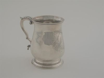An early George III mug with a leaf capped scroll