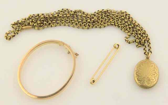 A 9ct gold bangle hinged and with safety chain a