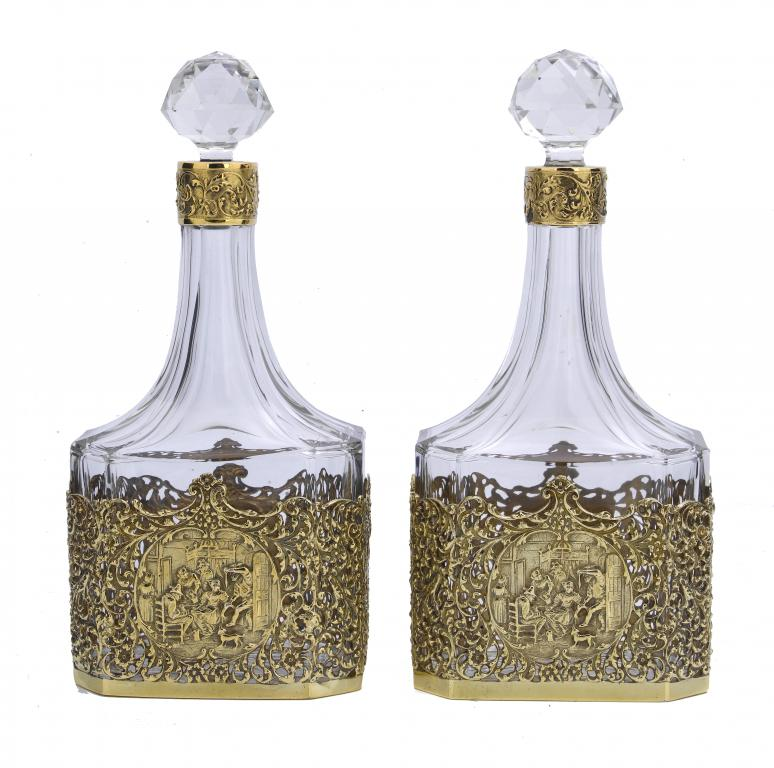 A PAIR OF CONTINENTAL SILVER GILT MOUNTED GLASS DECANTERS AND