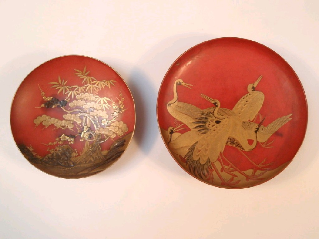 A Japanese red lacquered shallow circular dish hand painted in