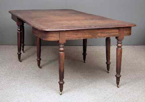 A George III mahogany dining table the top with moulded