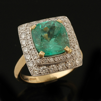 An emerald and diamond ring The rectangular cluster centrally set