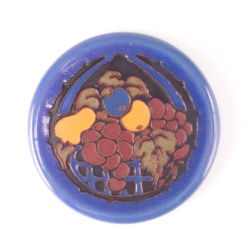 CALIFORNIA FAIENCE Circular trivet decorated in cuenca with a basket