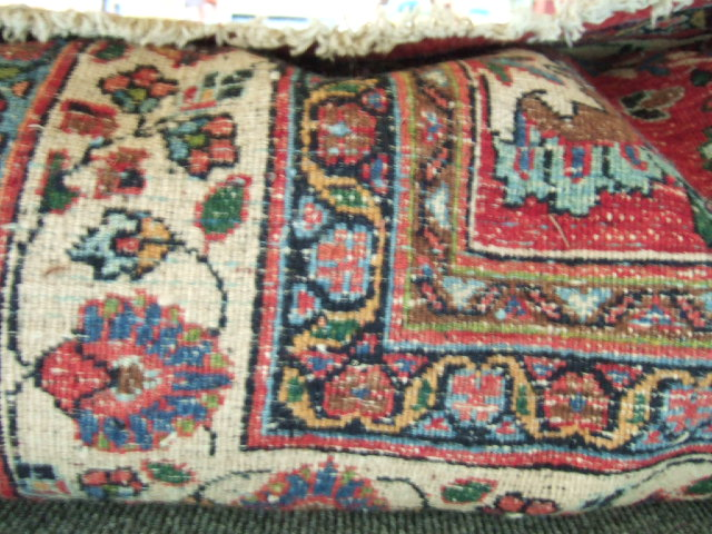 A Mashhad carpet Persian the burgundy field with an allover